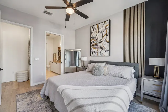 a bedroom with a large bed and a chandelier