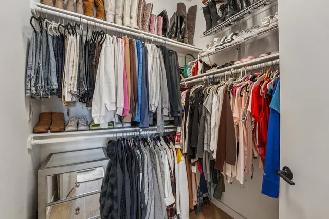 a view of walk in closet with clothes