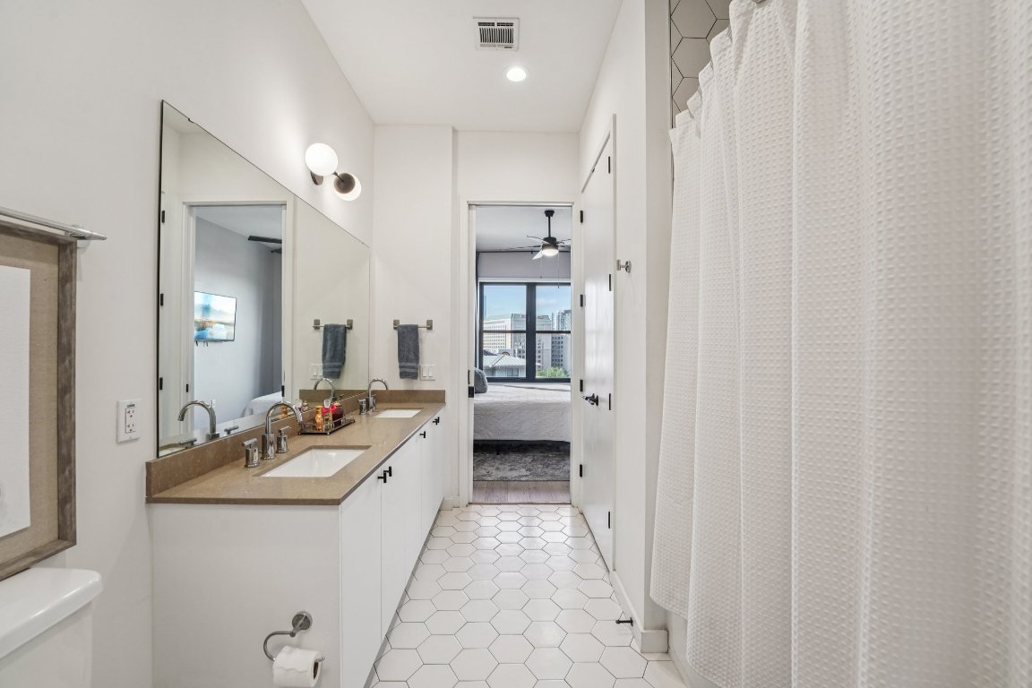 800 Embassy Drive, Unit 429 Austin, TX 78702 - Photo 18 of 40 a bathroom with a double vanity sink and mirror