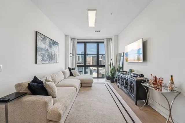 a living room with furniture large window and a flat screen tv