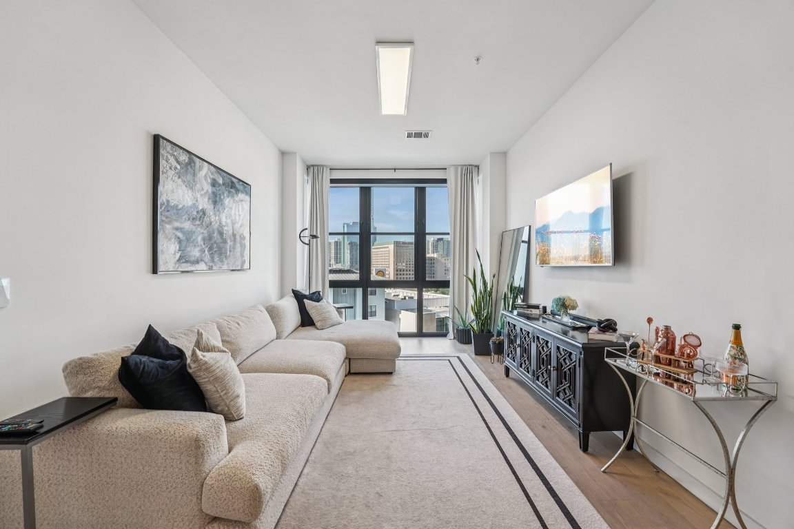 800 Embassy Drive, Unit 429 Austin, TX 78702 - Photo 2 of 40 a living room with furniture large window and a flat screen tv