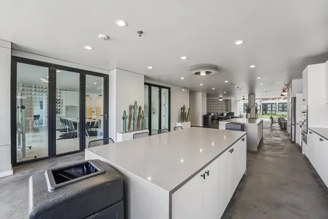 a large white kitchen with a large window and stainless steel appliances
