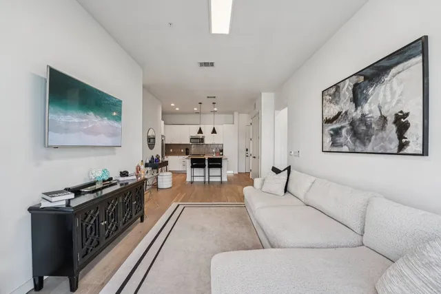 a living room with furniture and a painting on the wall