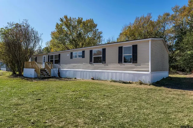 a view of a house with a yard and sitting area