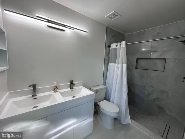 a bathroom with a sink toilet and shower