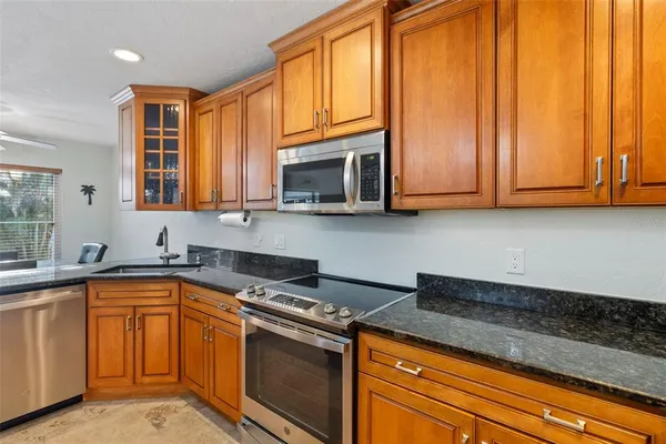 a kitchen with stainless steel appliances granite countertop a sink and a refrigerator