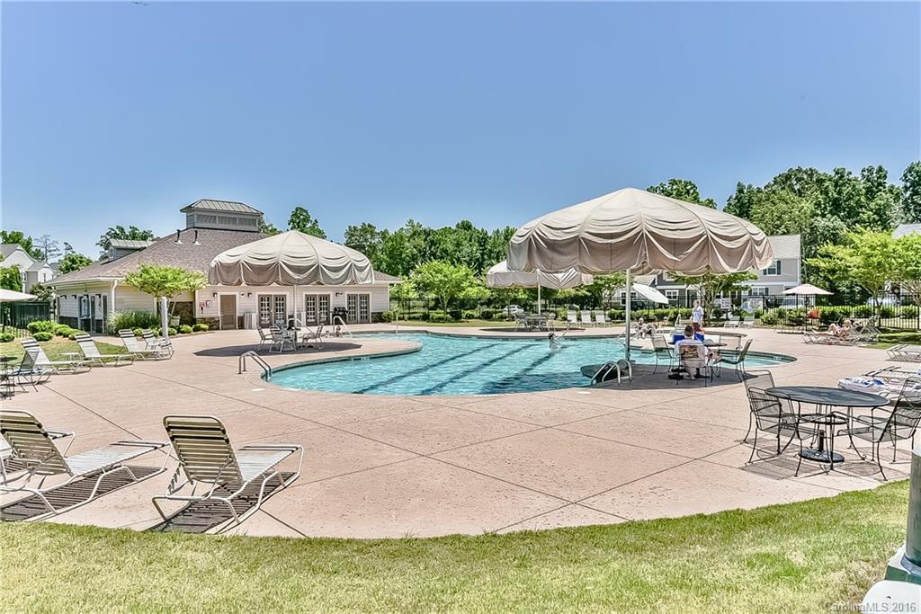 653 Potter Place Road, Unit 110 Fort Mill, SC 29708 - Photo 3 of 22 a view of a swimming pool with lawn chairs under an umbrella