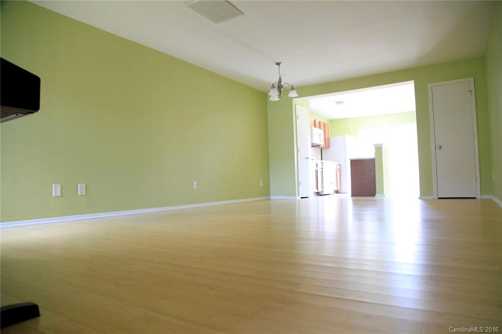 653 Potter Place Road, Unit 110 Fort Mill, SC 29708 - Photo 7 of 22 an empty room with wooden floor and windows