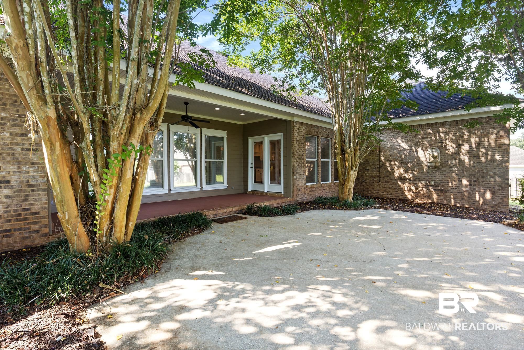 11261 Halcyon Loop Daphne, AL 36526 - Photo 31 of 41 Expansive concrete patio bordered by mature trees and lush ground cover