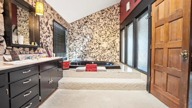 a bedroom with a bed dresser and a large window