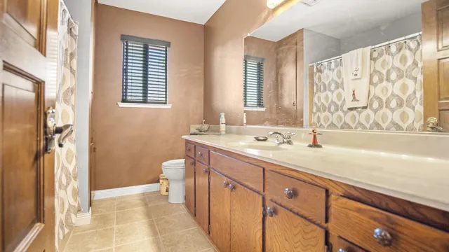 a spacious bathroom with a granite countertop sink a toilet and a shower