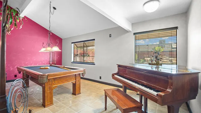 a room with pool table and windows