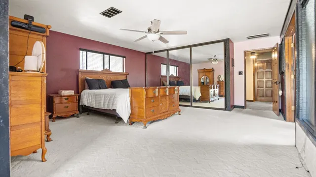 a spacious bedroom with a bed and a chandelier