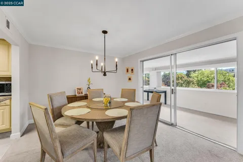 a view of a dining room and livingroom furniture a chandelier and wooden floor