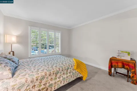 a bed sitting in a bedroom next to a window
