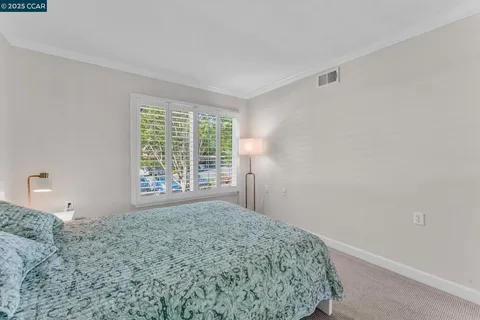 a bedroom with a bed and a large mirror