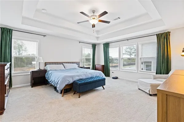 a spacious bedroom with a bed and glass walk in closet
