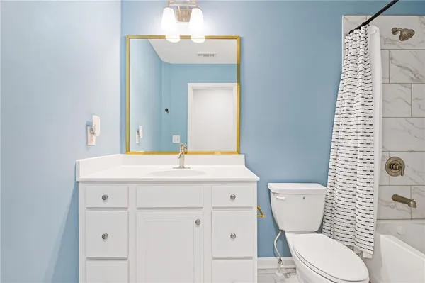 a bathroom with a toilet a sink and mirror