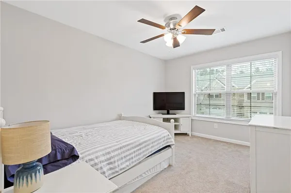 a bedroom with a bed window and a flat screen tv