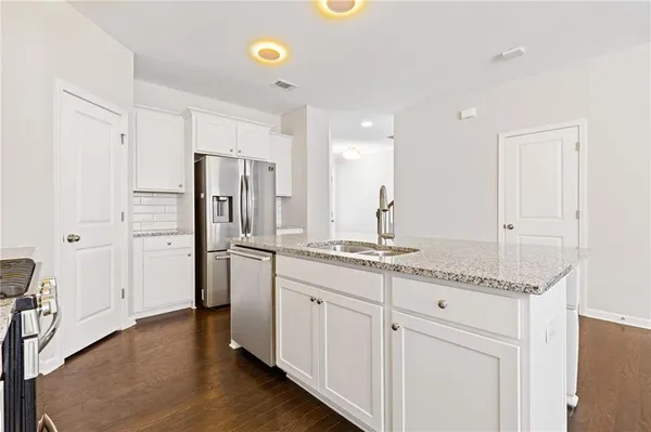 a kitchen with stainless steel appliances granite countertop a refrigerator and a stove
