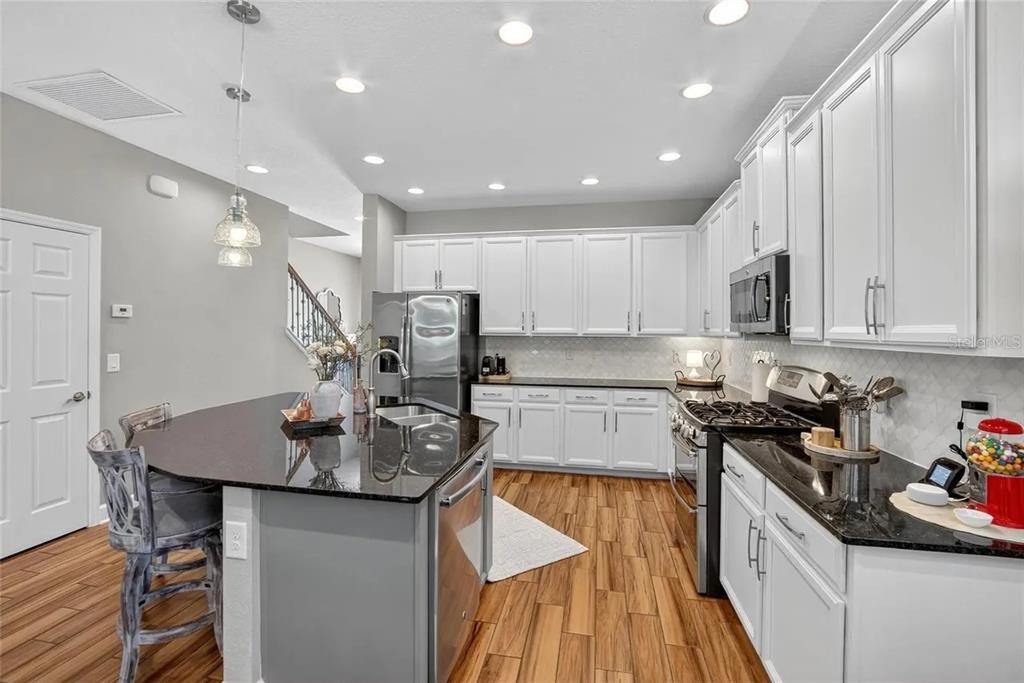 14302 Rolling Dune Road Lithia, FL 33547 - Photo 11 of 88 a kitchen with stainless steel appliances granite countertop a sink a stove and a refrigerator