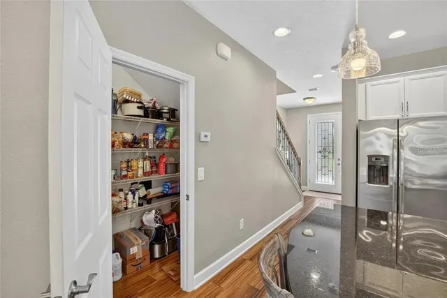 a dining room with wooden floor a chandelier a wooden table and chairs