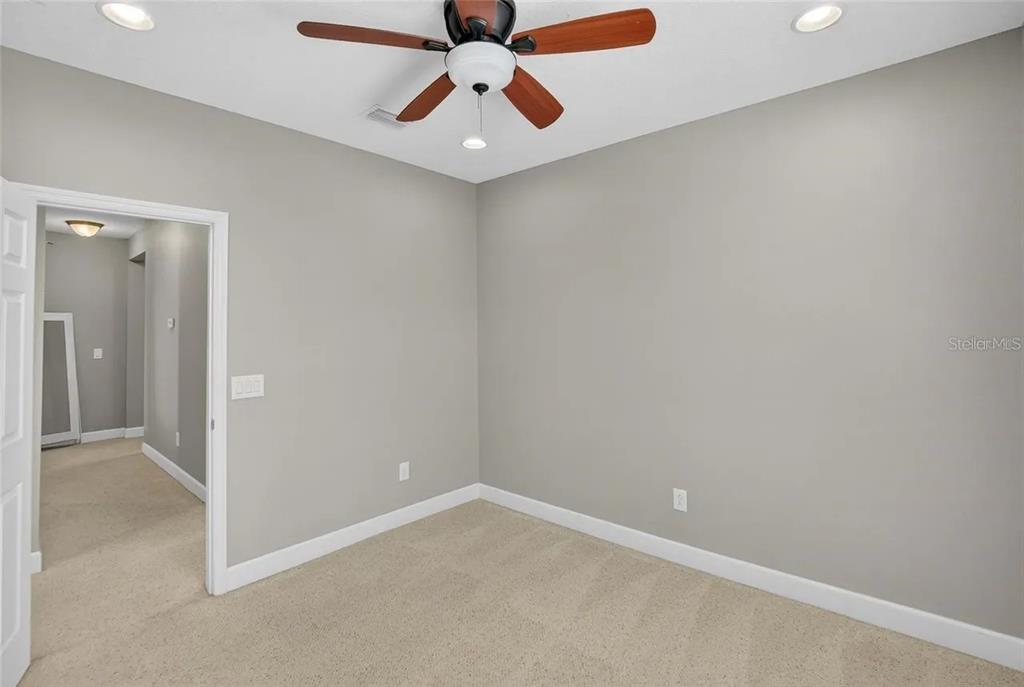 14302 Rolling Dune Road Lithia, FL 33547 - Photo 51 of 88 an empty room with a ceiling fan and carpet