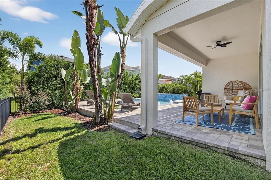 14302 Rolling Dune Road Lithia, FL 33547 - Photo 57 of 88 a view of a patio with table and chairs potted plants and palm tree