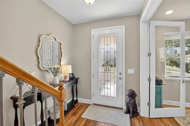 a kitchen with stainless steel appliances granite countertop a stove top oven a sink dishwasher a dining table and chairs with wooden floor