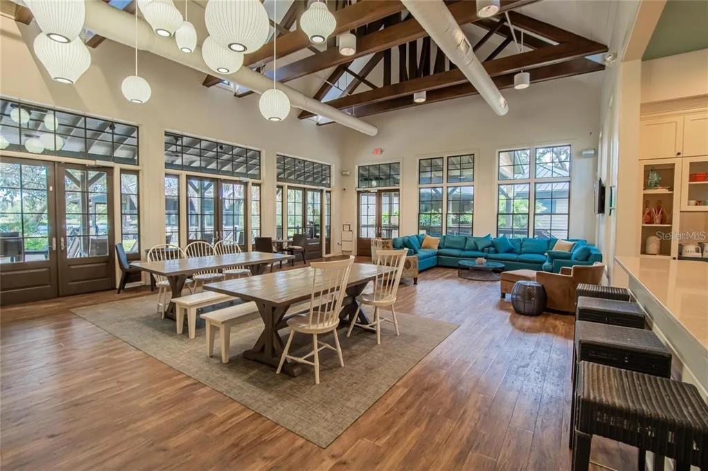 14302 Rolling Dune Road Lithia, FL 33547 - Photo 69 of 88 a dining room with wooden floor a chandelier a wooden table and chairs