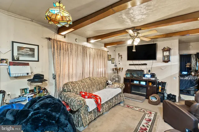 a living room with furniture a flat screen tv and a window
