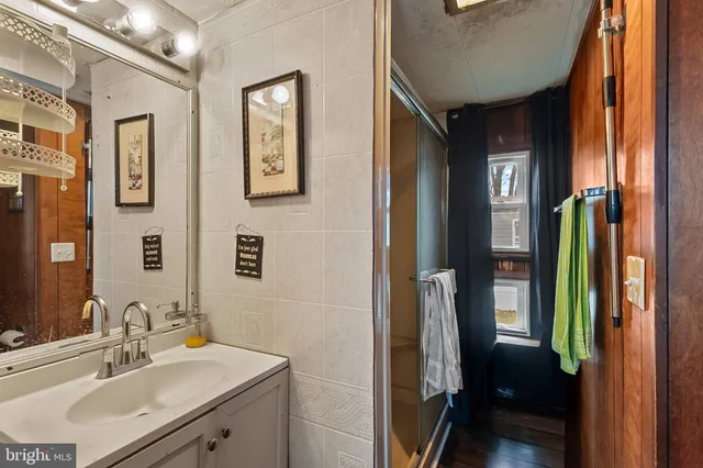 a bathroom with a sink a mirror and shower