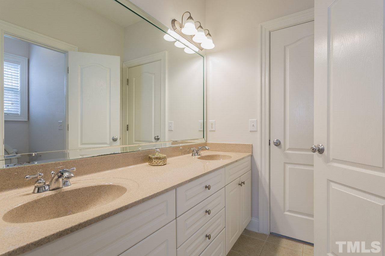 4208 Russling Leaf Lane Raleigh, NC 27613 - Photo 23 of 25 a bathroom with a sink and a mirror