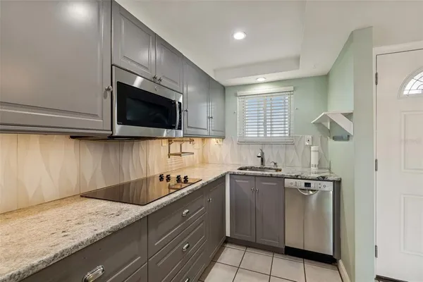 a kitchen with stainless steel appliances granite countertop a sink a stove and microwave