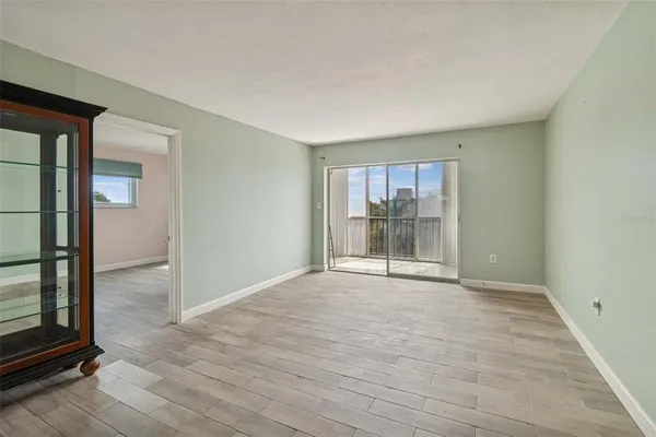 an empty room with sliding door and wooden floor
