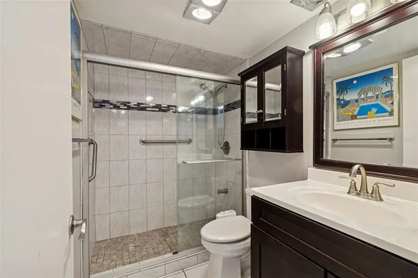 a bathroom with a sink a toilet a mirror and shower