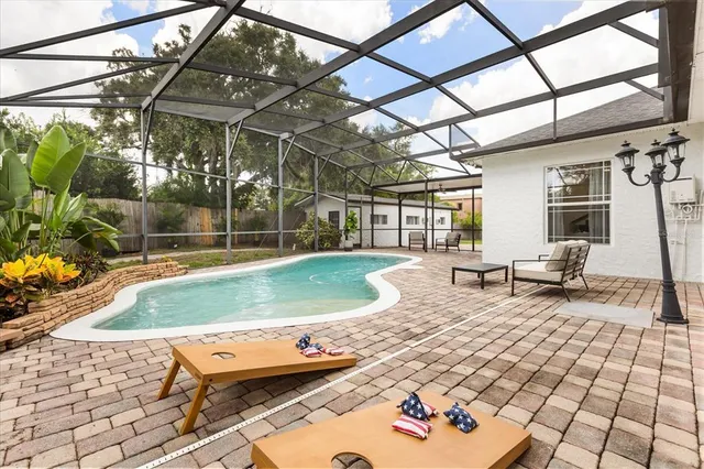 a view of house with backyard and trees in the background