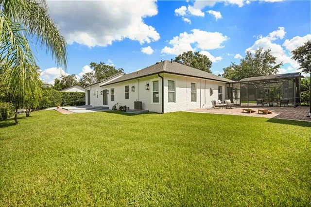 an aerial view of a house with a yard and lake view