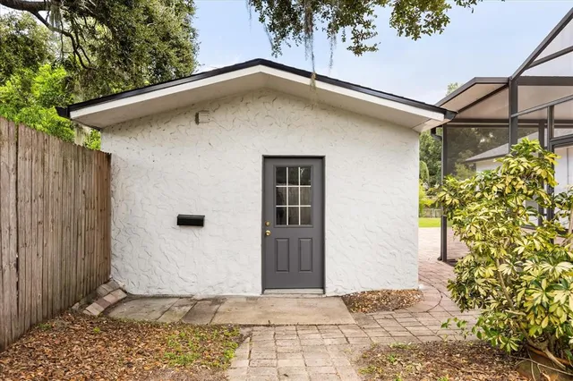 an aerial view of a house with swimming pool and large trees