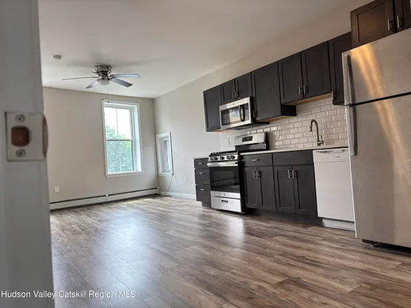 a kitchen with stainless steel appliances granite countertop a refrigerator a stove a sink and a microwave