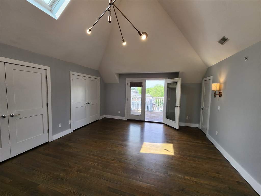 84 Romsey Street, Unit 3 Boston, MA 02125 - Photo 16 of 20 an empty room with wooden floor and windows