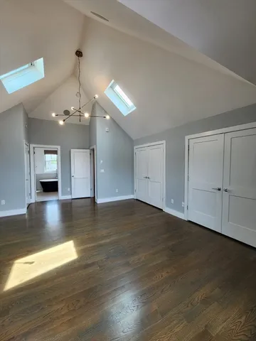 a view of a room with wooden floor chandelier and windows
