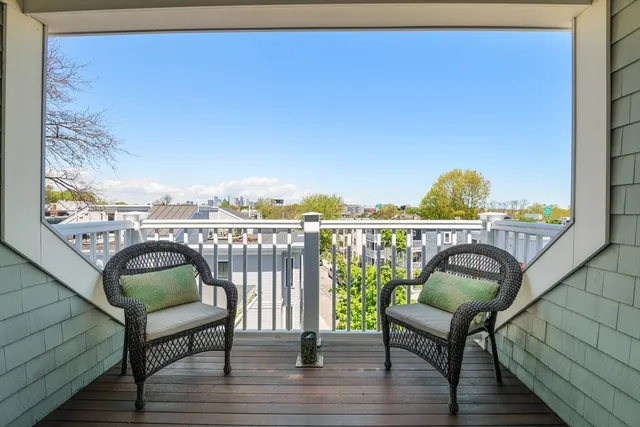 a balcony with wooden floor and outdoor seating