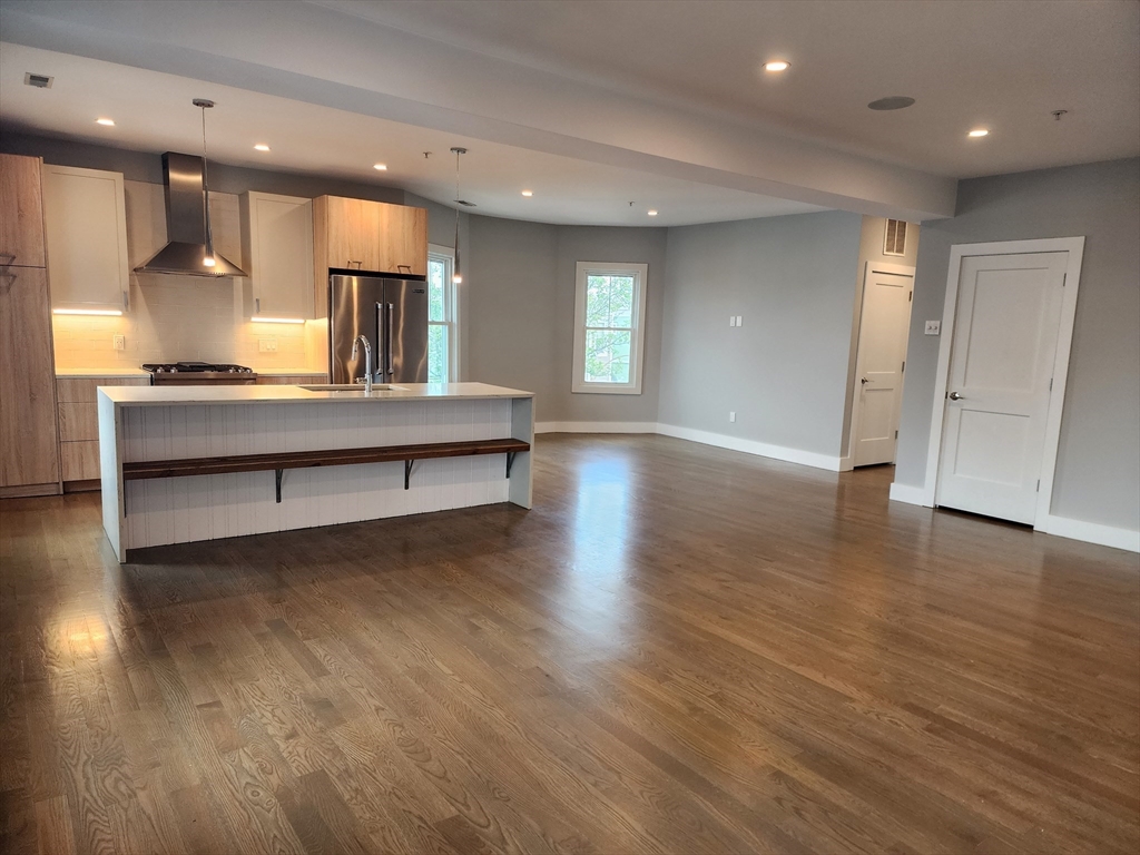 84 Romsey Street, Unit 3 Boston, MA 02125 - Photo 2 of 20 a view of kitchen with cabinets and wooden floor