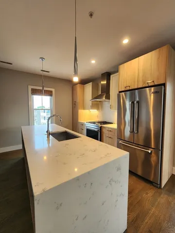 a kitchen with refrigerator and wooden floor