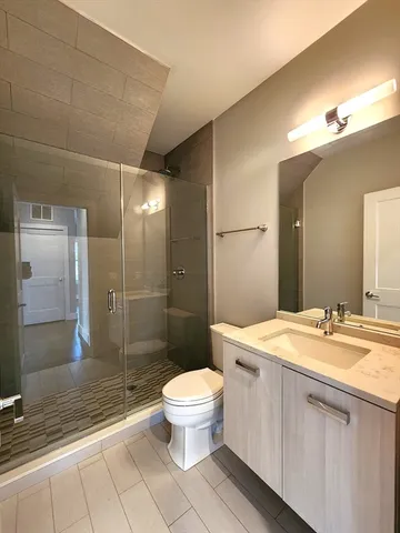 a bathroom with a sink a toilet a mirror and shower