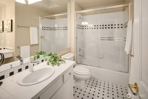 a bathroom with a sink toilet a mirror and shower