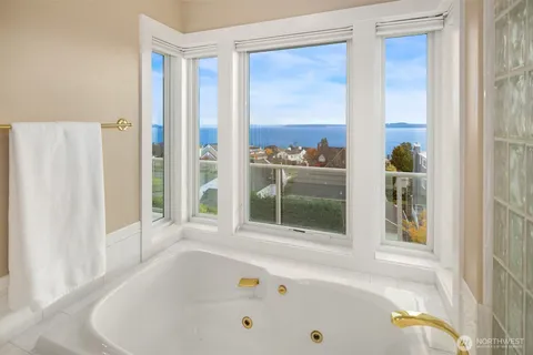 a bathroom with bathtub and a window