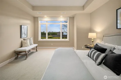 a bedroom with a bed and a large window