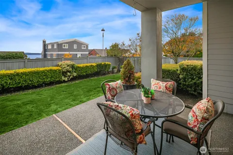 a view of a patio with table and chairs and a garden